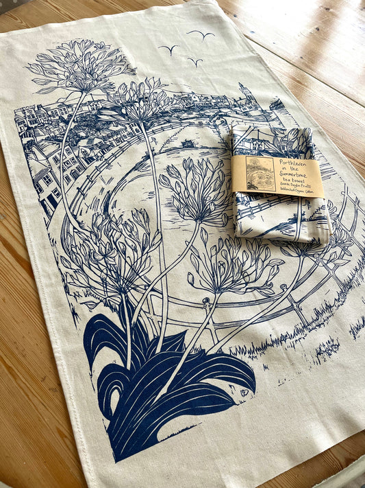 Organic cotton teatowel featuring a navy blue screen print of an original lino print of Porthleven in Cornwall.