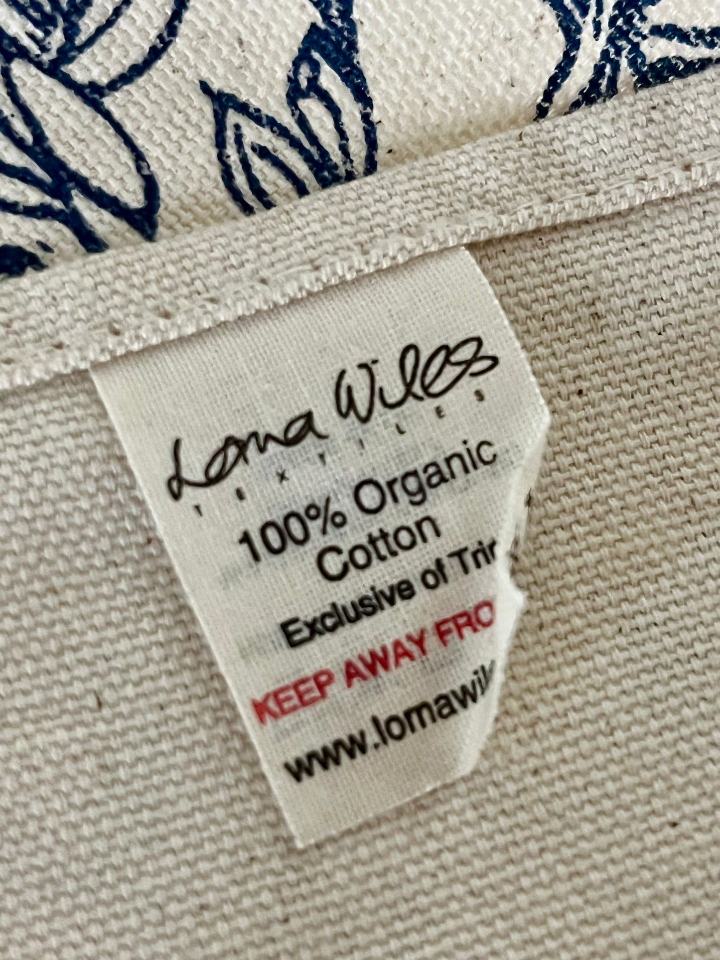 Label on tea towel indicating 100% organic cotton