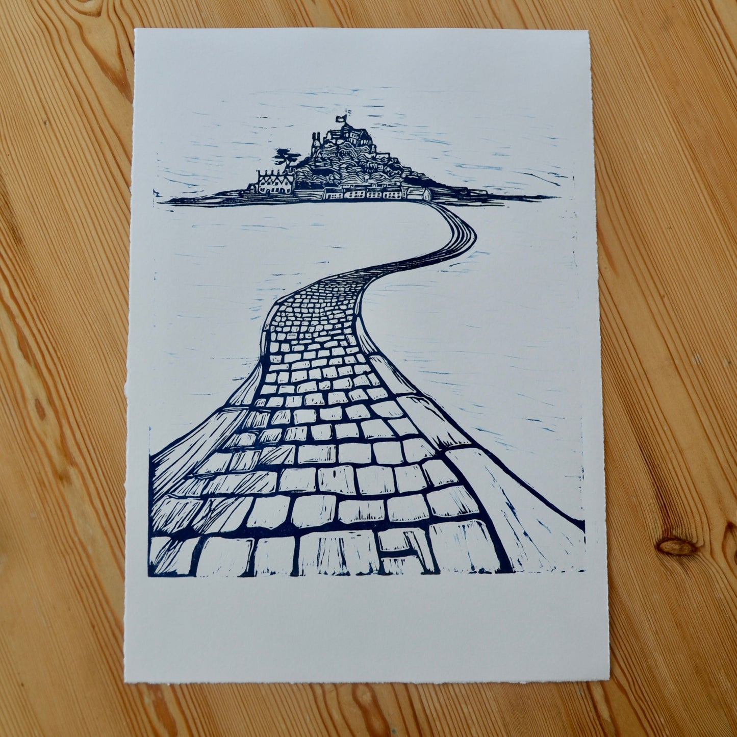 Navy blue lino print of St Michael's Mount and her famous causeway