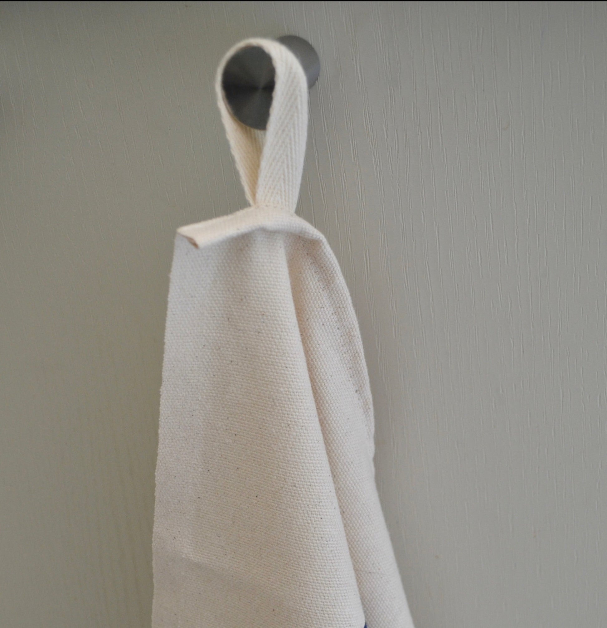 Each "Sardines in a Tin" Organic Cotton Tea towel has a useful hanging loop