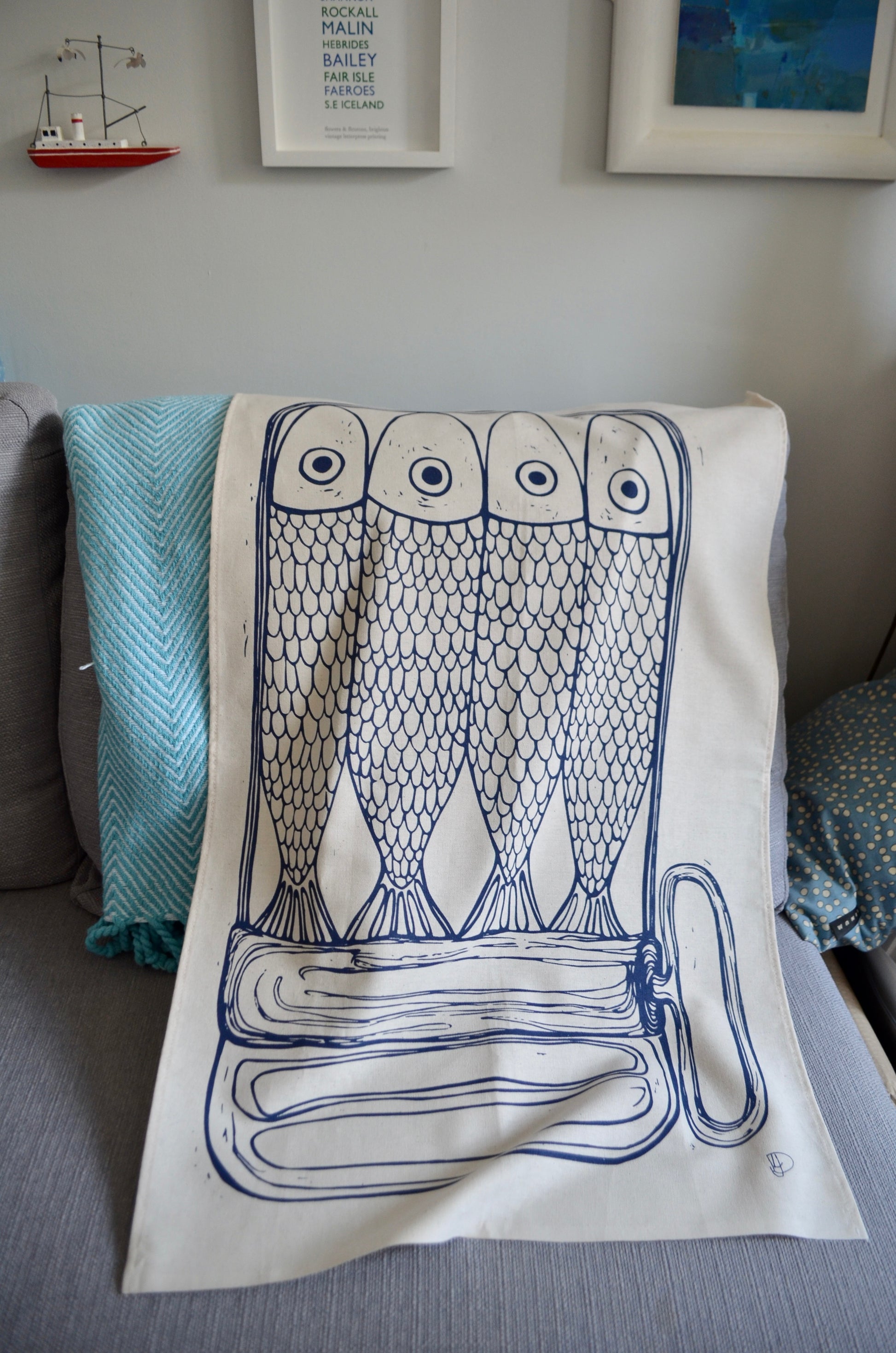 This image shows the tea towel draped in a coastal home, complimenting the grey, blue, and white colour scheme
